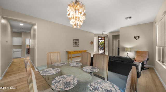 dining area featuring a chandelier and light wood-type flooring