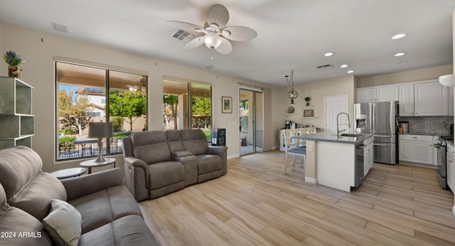 kitchen with decorative backsplash, light hardwood / wood-style flooring, a breakfast bar, white cabinetry, and appliances with stainless steel finishes