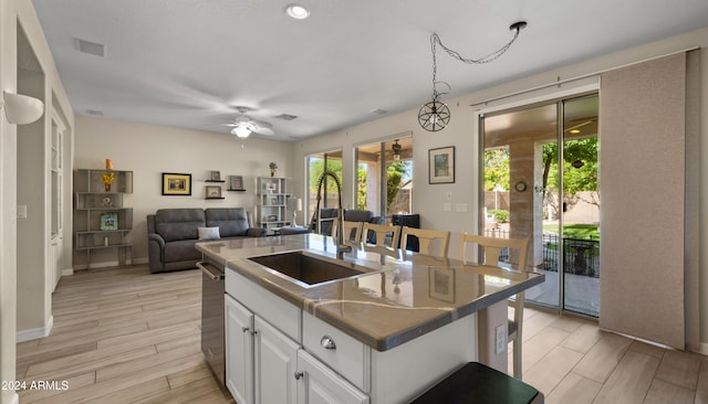 kitchen with sink, a center island, ceiling fan, light hardwood / wood-style floors, and white cabinets