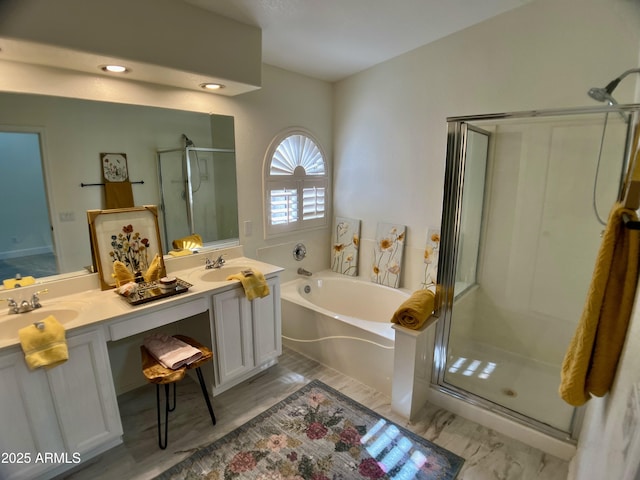 bathroom with a garden tub, a sink, a stall shower, and double vanity