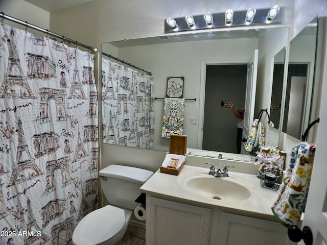 bathroom featuring toilet, curtained shower, and vanity