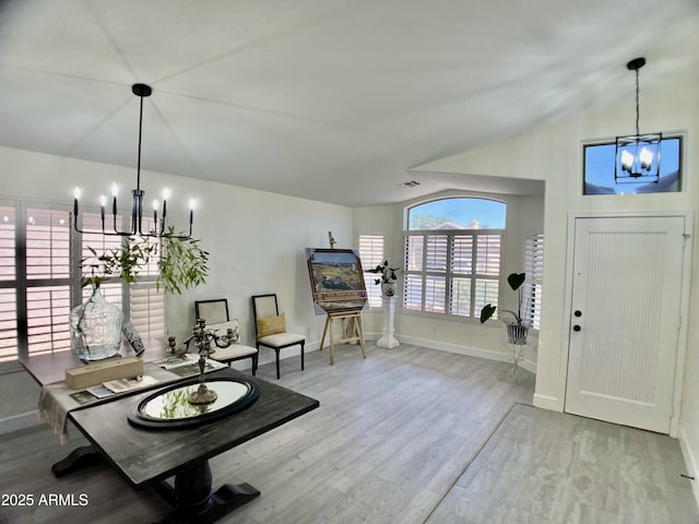 interior space featuring an inviting chandelier, baseboards, wood finished floors, and vaulted ceiling