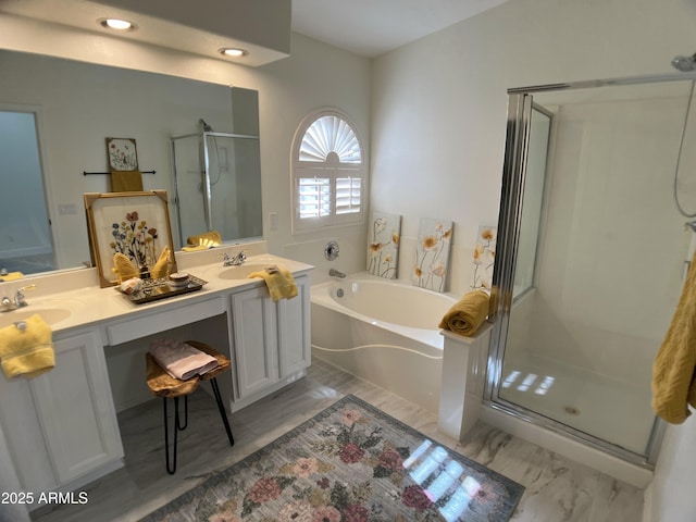 bathroom with double vanity, a shower stall, a sink, and a garden tub