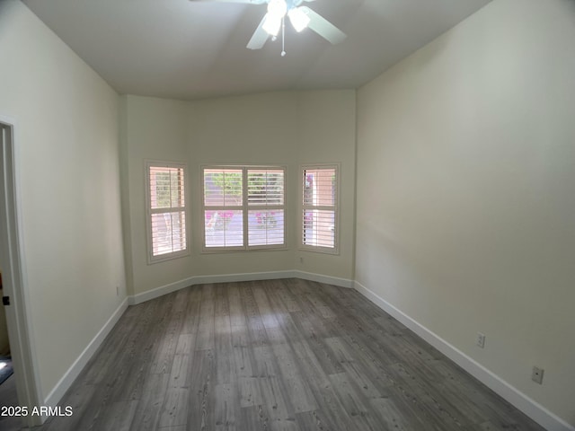 spare room with a ceiling fan, baseboards, a wealth of natural light, and wood finished floors