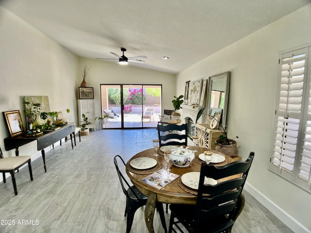dining area with a ceiling fan, baseboards, and lofted ceiling