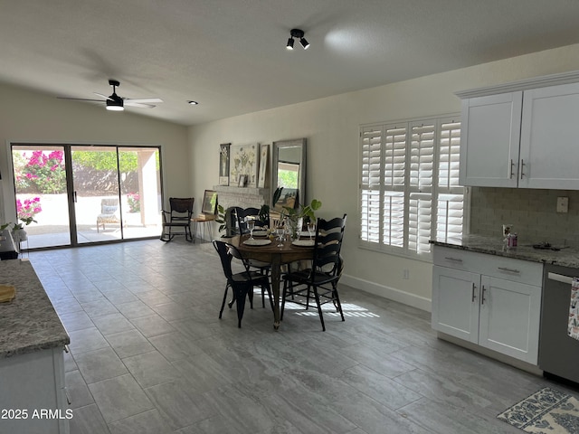 dining room with baseboards, ceiling fan, a healthy amount of sunlight, and vaulted ceiling