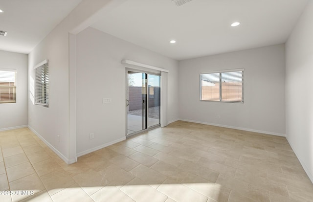 empty room featuring a wealth of natural light and light tile patterned flooring