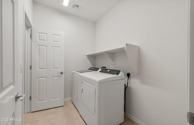 laundry area featuring light tile patterned floors and washing machine and clothes dryer