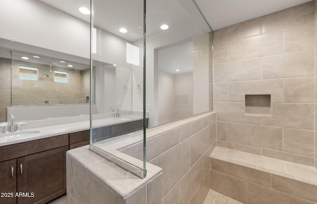 bathroom featuring tiled shower and vanity