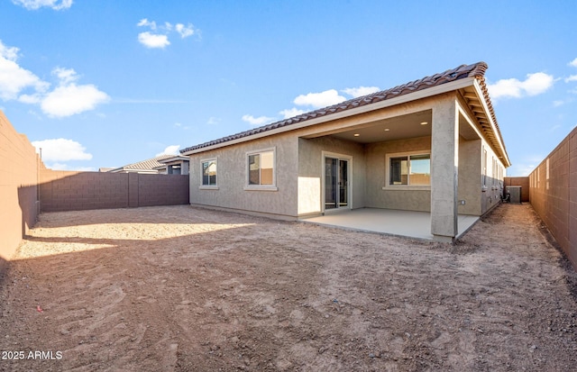 back of property with cooling unit and a patio area