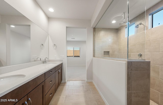 bathroom featuring vanity, a tile shower, tile patterned flooring, and plenty of natural light