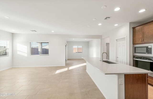 kitchen featuring an island with sink, appliances with stainless steel finishes, and sink