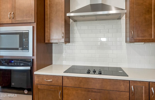 kitchen featuring tasteful backsplash, stainless steel appliances, and wall chimney exhaust hood