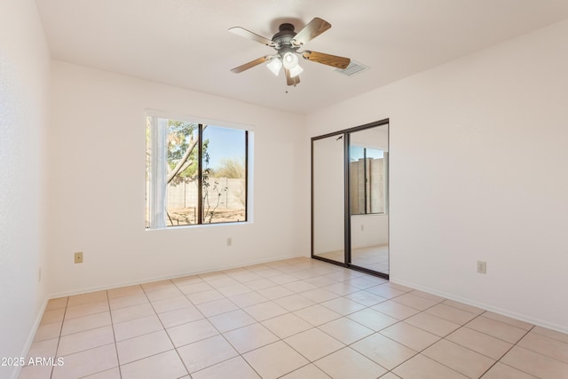 empty room featuring light tile patterned floors and ceiling fan