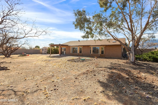 rear view of property with a patio area and a storage shed