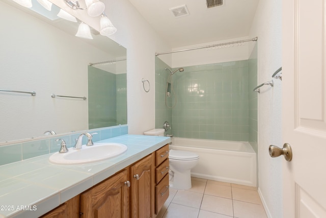 full bathroom featuring vanity, tiled shower / bath, toilet, and tile patterned floors