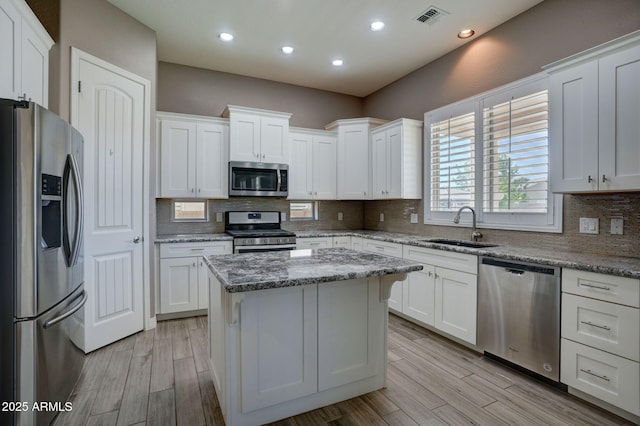 5552 N Kerwood Loop, Prescott Valley, AZ 86314 - kitchen with stainless steel appliances, white cabinets, decorative backsplash, light wood-style flooring, and recessed lighting