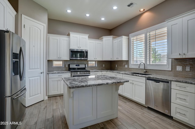 5552 N Kerwood Loop, Prescott Valley, AZ 86314 - kitchen with appliances with stainless steel finishes, white cabinets, tasteful backsplash, light wood-type flooring, and recessed lighting