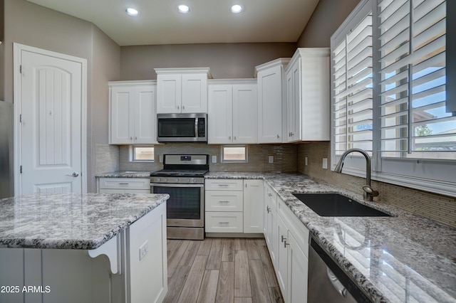 5552 N Kerwood Loop, Prescott Valley, AZ 86314 - kitchen featuring stainless steel appliances, white cabinetry, recessed lighting, light wood-style floors, and backsplash