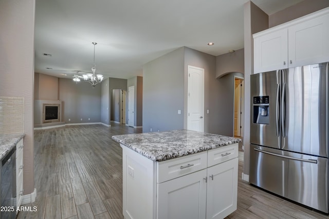 5552 N Kerwood Loop, Prescott Valley, AZ 86314 - kitchen featuring appliances with stainless steel finishes, arched walkways, a chandelier, light wood-style flooring, and light stone counters