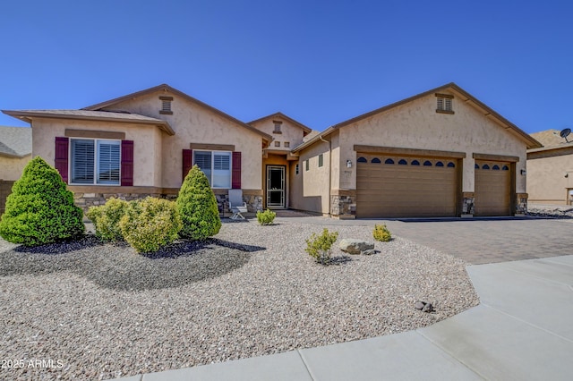5552 N Kerwood Loop, Prescott Valley, AZ 86314 - view of front of house with stone siding, a garage, stucco siding, and decorative driveway