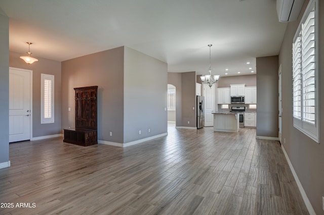 5552 N Kerwood Loop, Prescott Valley, AZ 86314 - unfurnished living room with a chandelier, light wood finished floors, healthy amount of natural light, and recessed lighting
