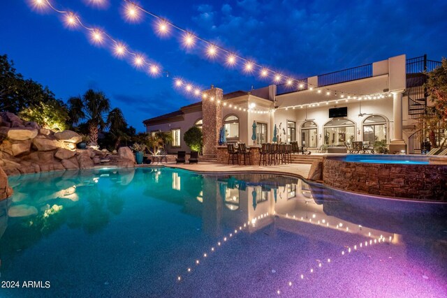 pool at twilight featuring a patio area