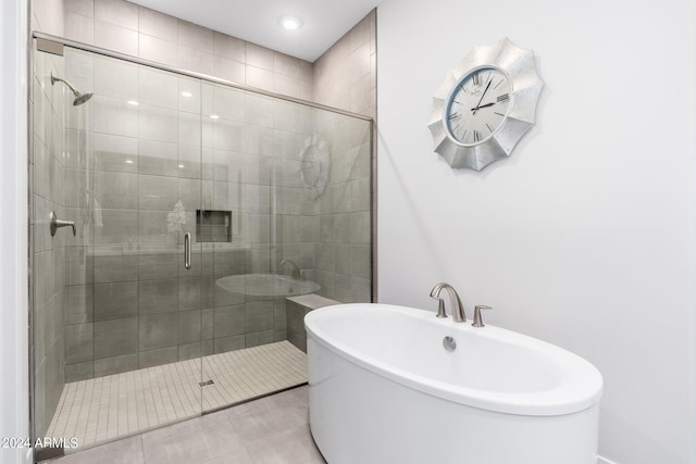 bathroom featuring tile patterned flooring and separate shower and tub