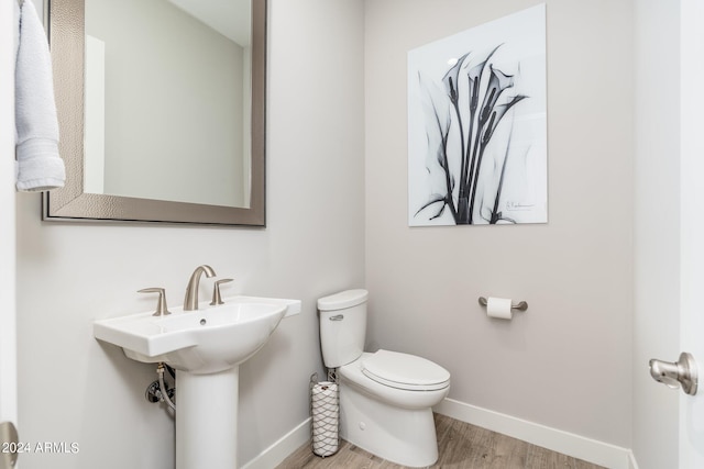 bathroom with toilet and hardwood / wood-style flooring