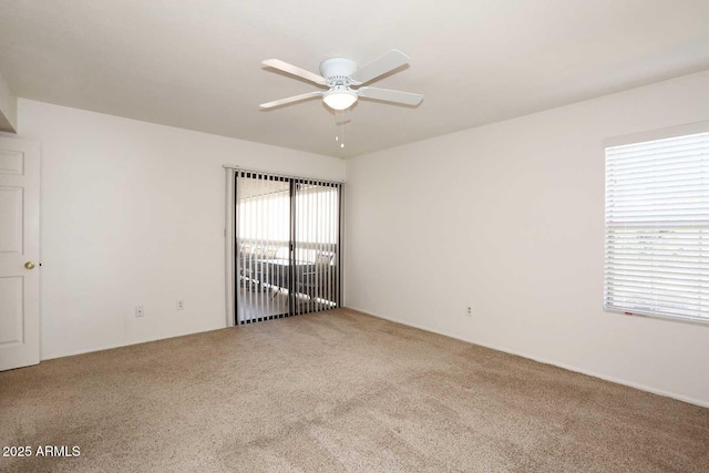 carpeted spare room featuring a ceiling fan
