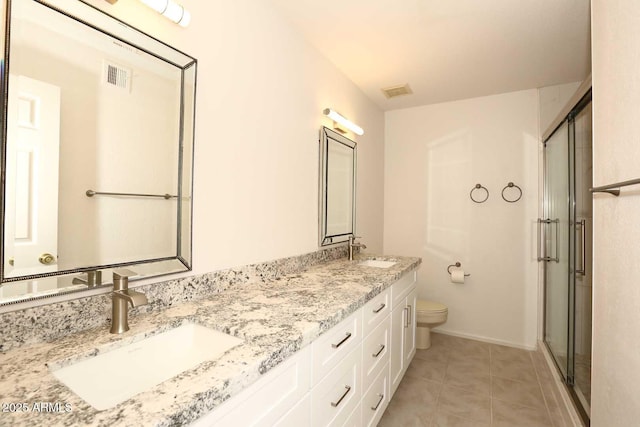 full bathroom featuring toilet, a stall shower, double vanity, tile patterned floors, and baseboards