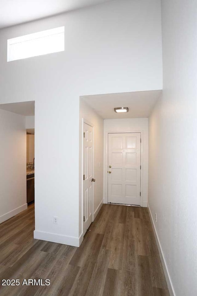 corridor featuring wood finished floors and baseboards