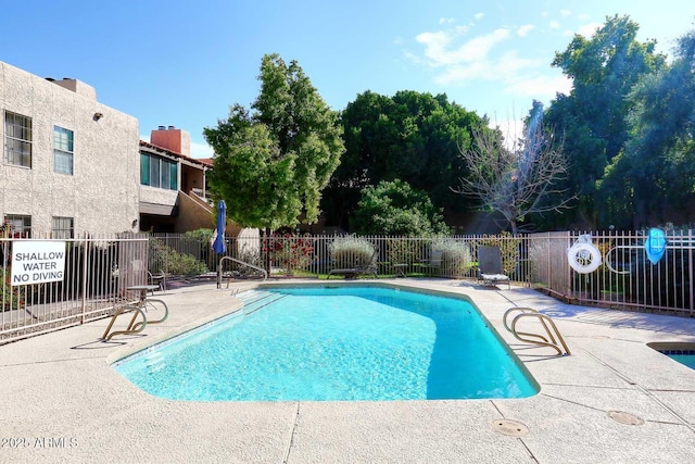 community pool with a patio and fence