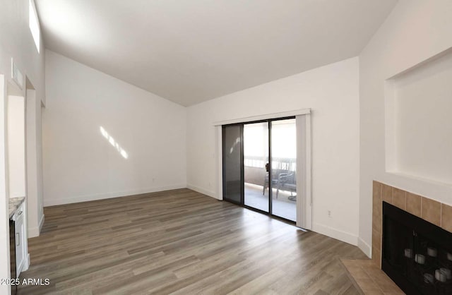 unfurnished living room featuring a fireplace, light wood-type flooring, and baseboards