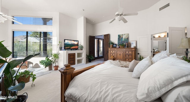 carpeted bedroom featuring ceiling fan and a towering ceiling