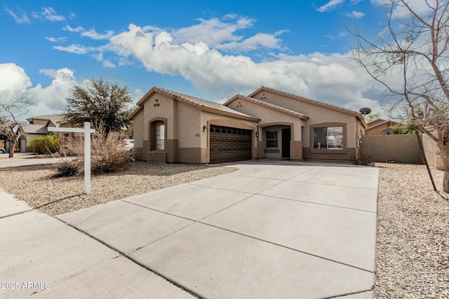 mediterranean / spanish-style home with an attached garage, fence, a tile roof, driveway, and stucco siding