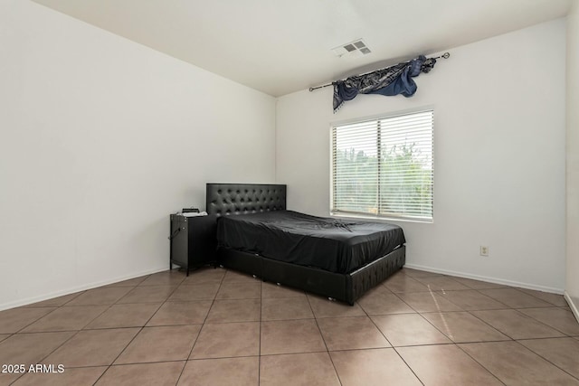 bedroom with visible vents, baseboards, and light tile patterned flooring