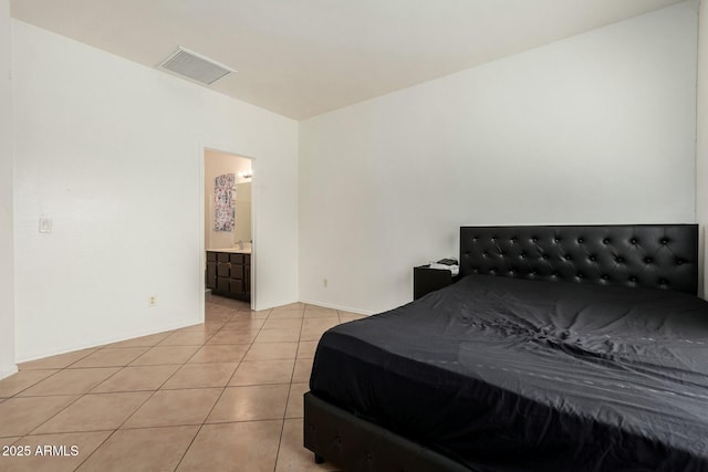 bedroom featuring light tile patterned flooring, ensuite bath, and visible vents