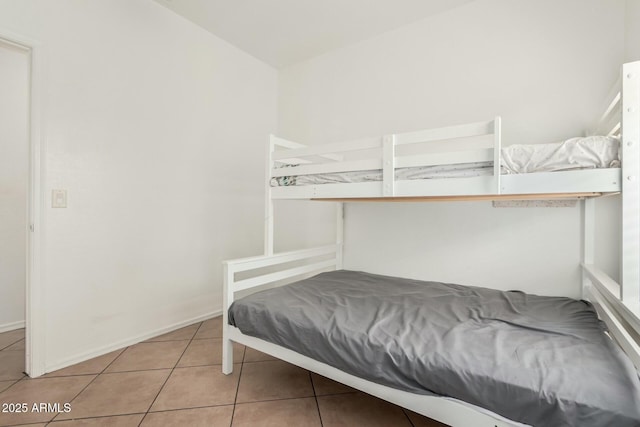 tiled bedroom featuring baseboards