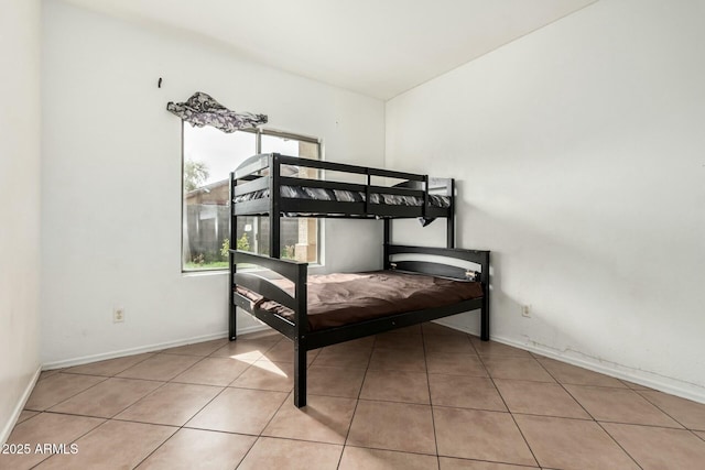 bedroom featuring tile patterned flooring and baseboards