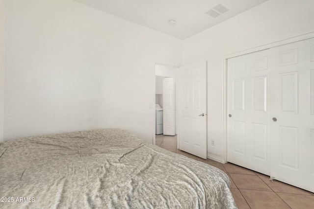 bedroom with washer / dryer, visible vents, and light tile patterned floors