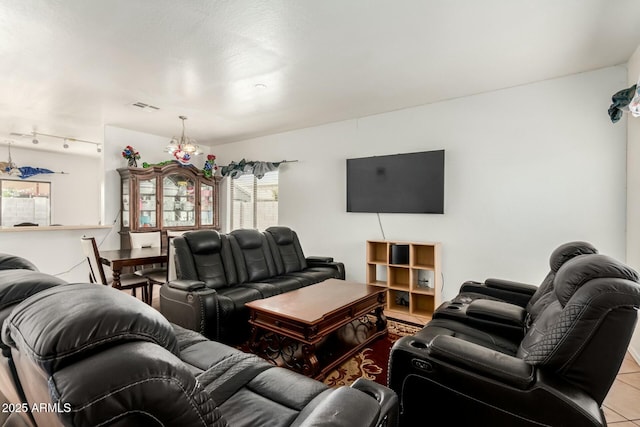 tiled living room with rail lighting and visible vents