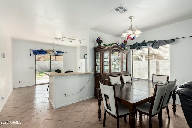 dining room featuring a chandelier, light tile patterned flooring, rail lighting, and visible vents