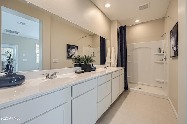 full bath featuring walk in shower, visible vents, and a sink