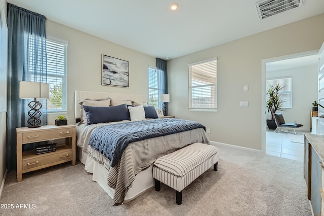 bedroom with visible vents, light colored carpet, and baseboards