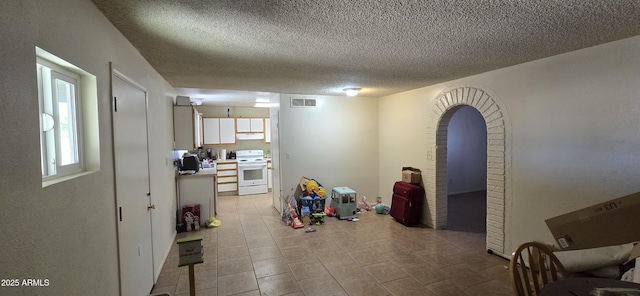 10408 W Devonshire Ave, Phoenix, AZ 85037 - rec room with a textured ceiling, arched walkways, and tile patterned floors