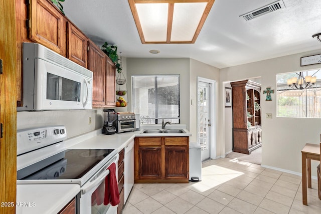 4725 E Brown Rd Unit 79, Mesa, AZ 85205 - kitchen featuring white appliances, light countertops, a chandelier, brown cabinetry, and light tile patterned floors