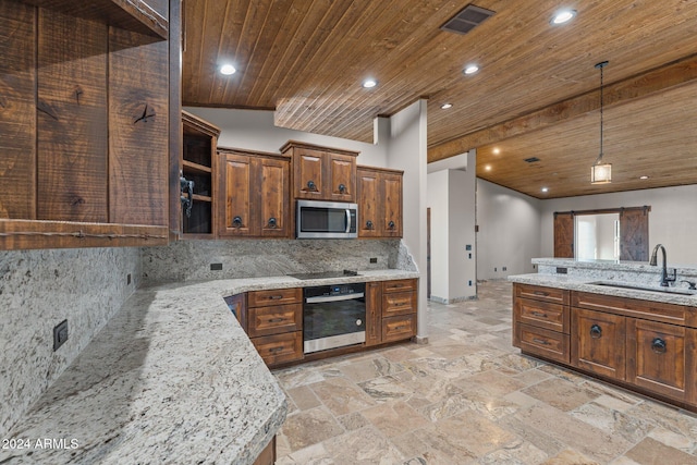 kitchen featuring a sink, stainless steel microwave, wall oven, a barn door, and wooden ceiling