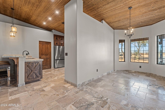 unfurnished dining area with baseboards, wood ceiling, stone tile flooring, high vaulted ceiling, and a sink