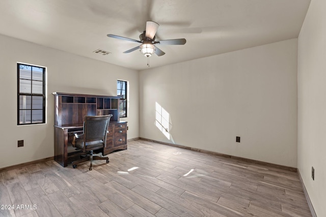 office area with light wood-type flooring, visible vents, baseboards, and ceiling fan